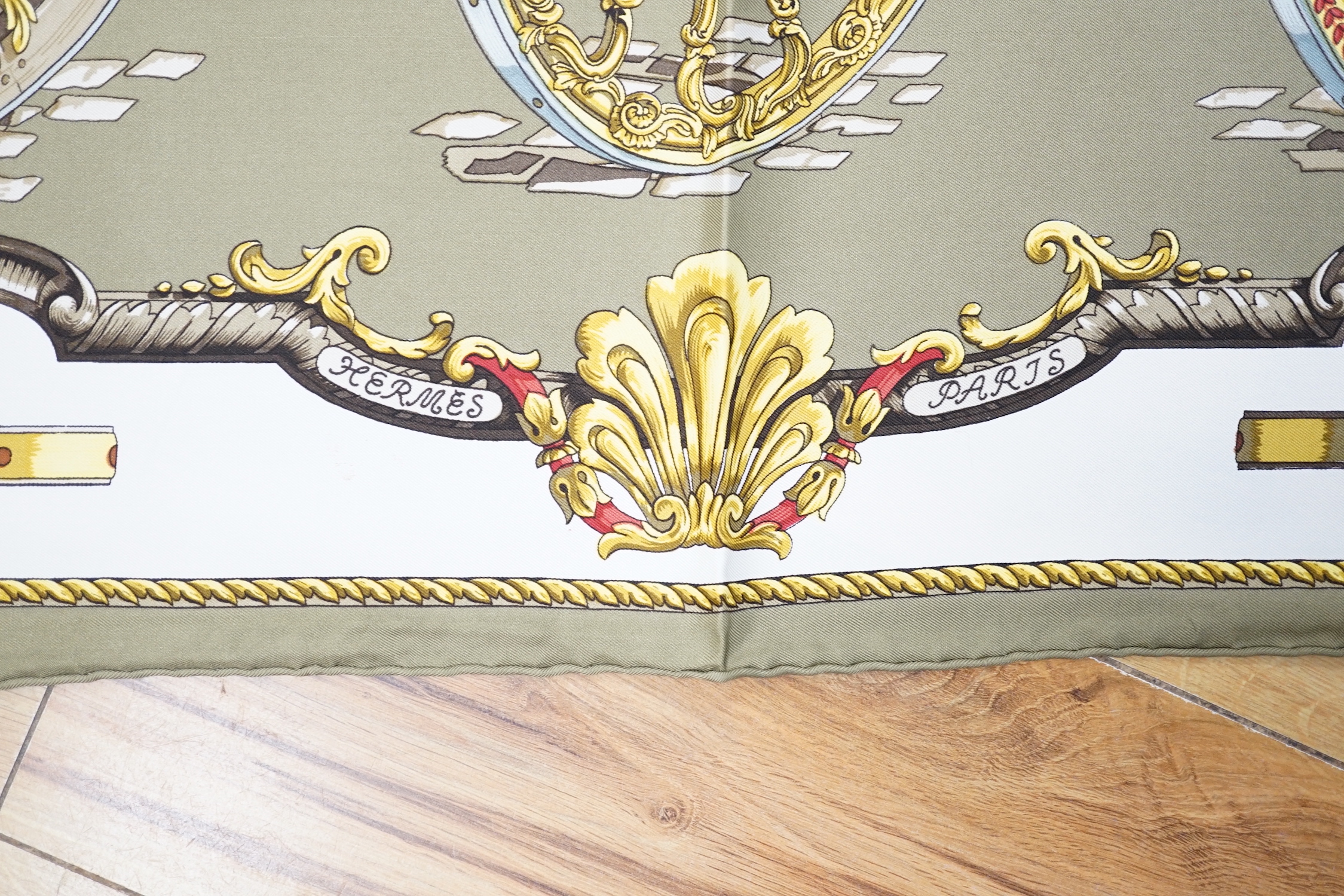 Four vintage Hermes silk scarves including one retailed by Harrods comprising, Selles A Housse, Roues de Canon, Passementerie and a rectangular Brides de Gala example